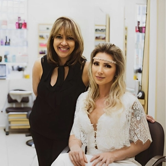 Elaine e noiva sorrindo juntas no salão, penteado boho com tiara de flores